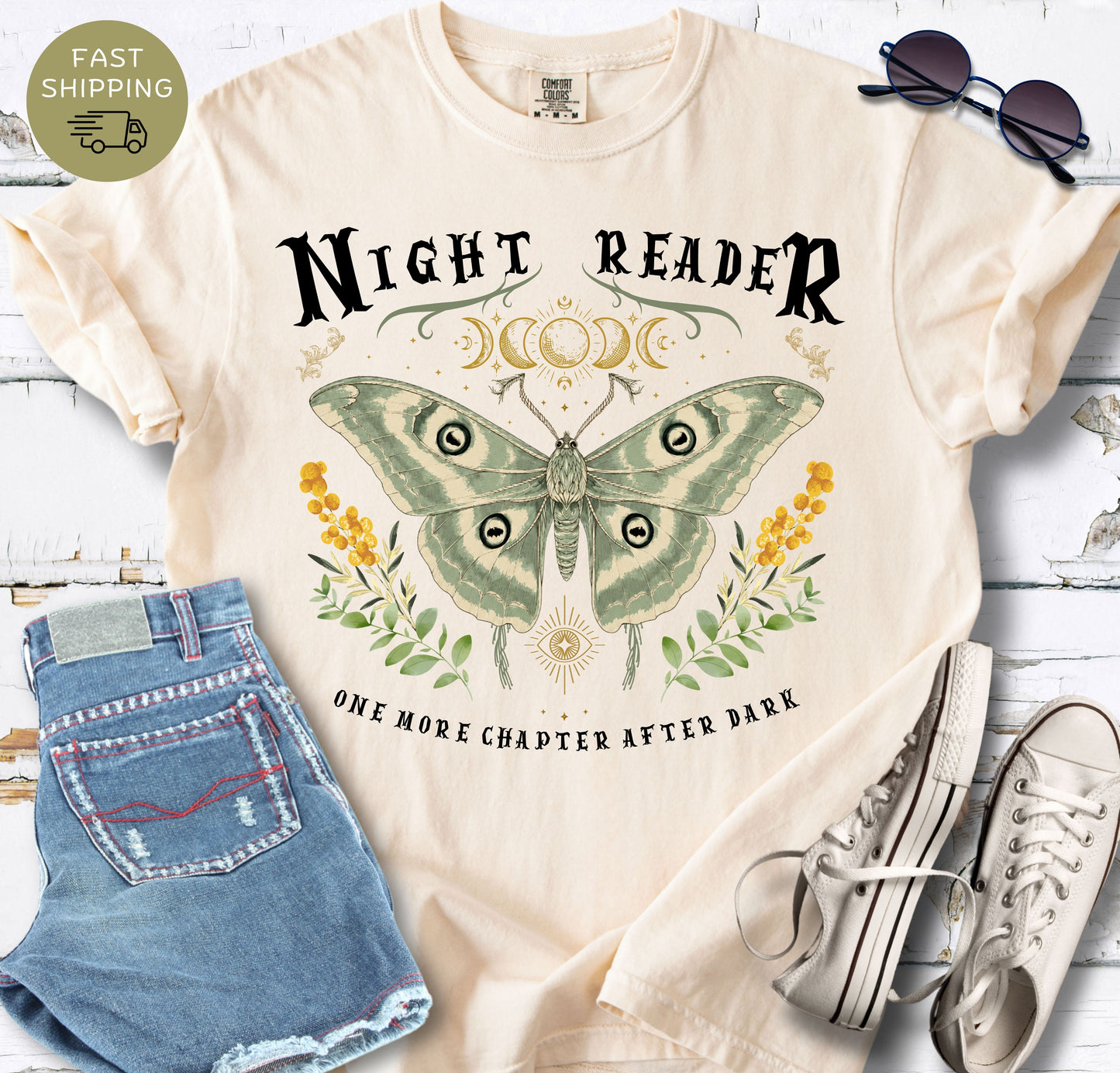 Book lover graphic tee with a large sage green moth, celestial moon details and botanical accents.