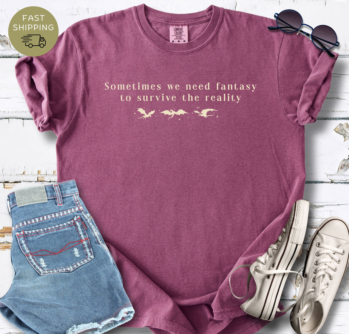Bookish dragon t-shirt with the phrase Sometimes we need fantasy to survive the reality.