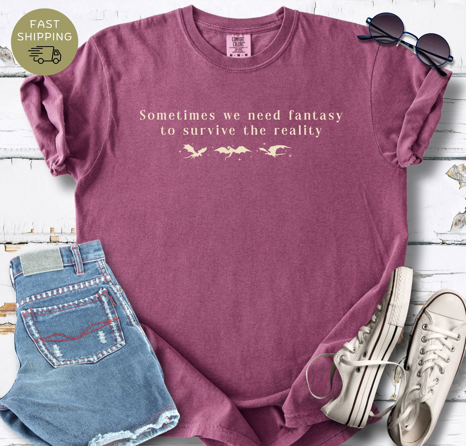 Bookish dragon t-shirt with the phrase Sometimes we need fantasy to survive the reality.