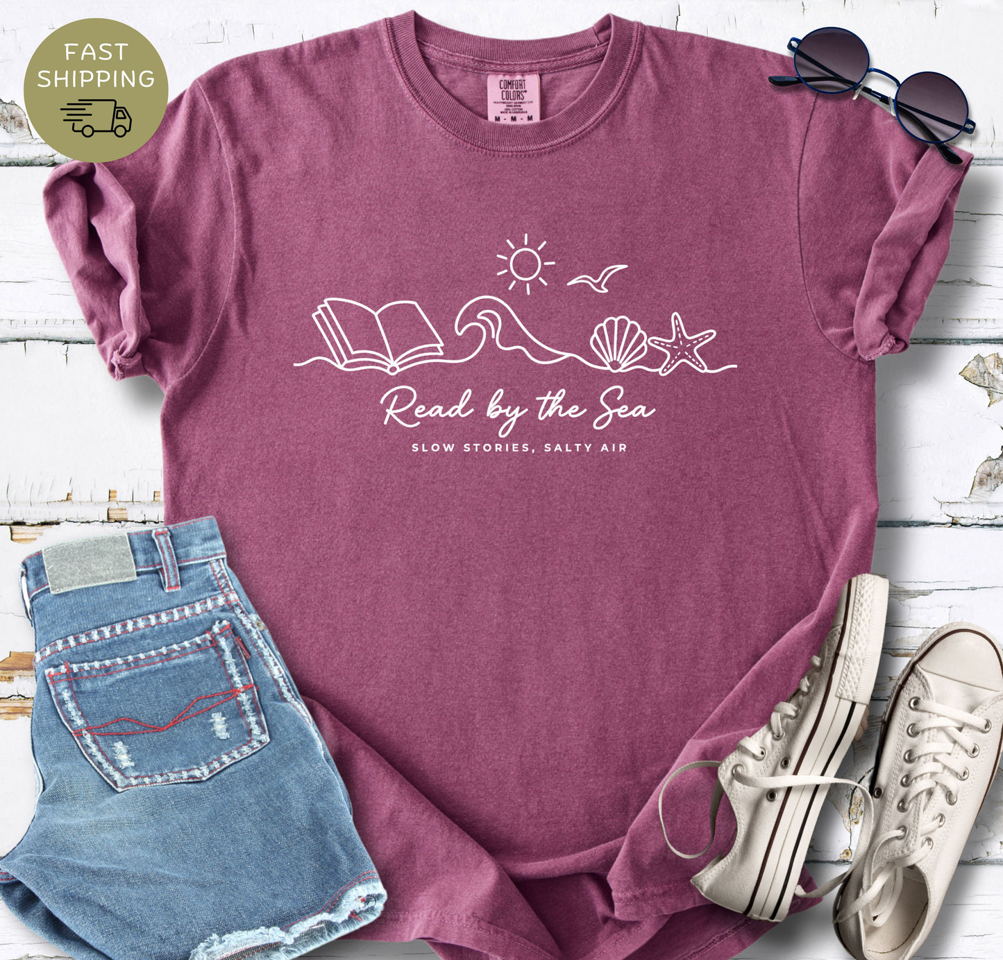 Coastal aesthetic reader tee with ocean, sun, and open book design