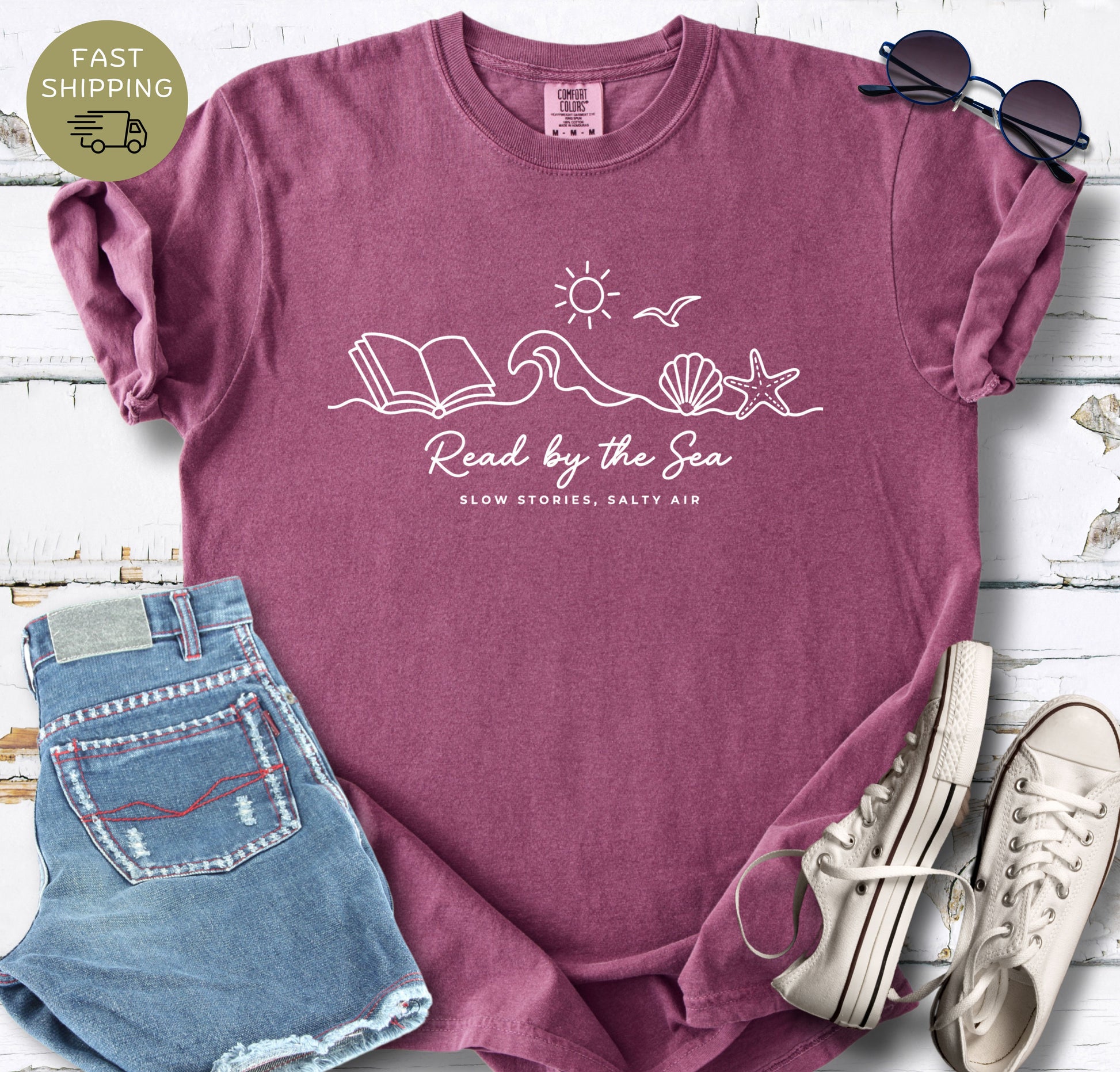 Coastal aesthetic reader tee with ocean, sun, and open book design