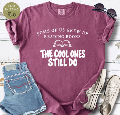 Bookish graphic tee with bold white lettering and open book icon on a berry shirt.