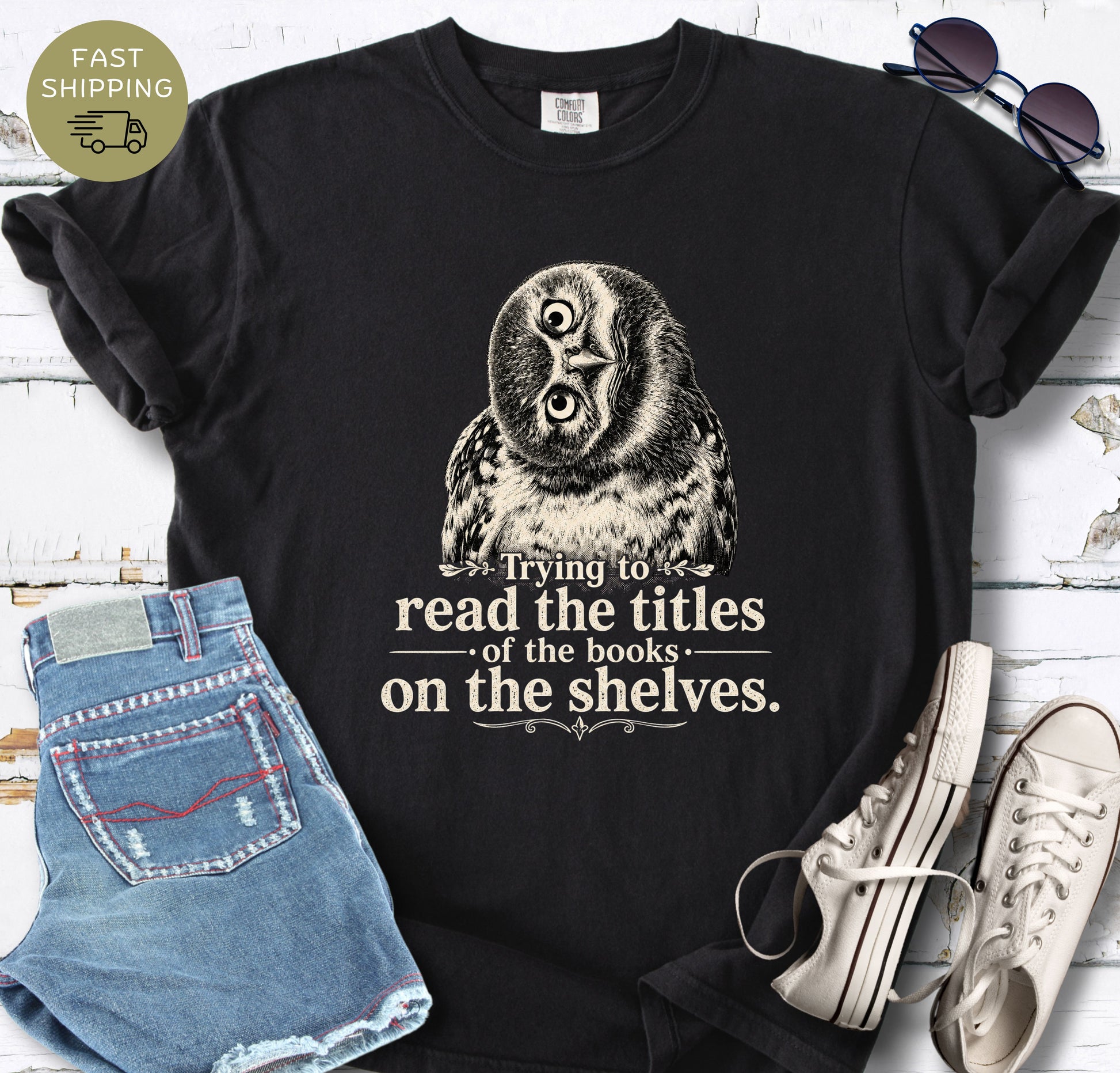 Comfort Colors reading shirt with a curious owl graphic and text about reading book titles on shelves.