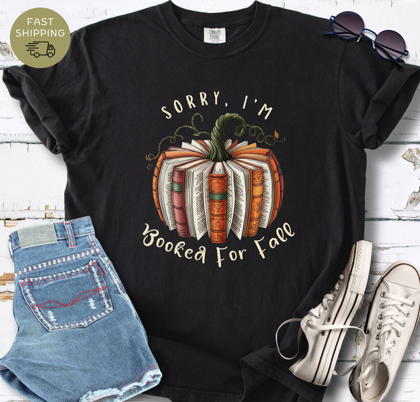 Book lover fall tee with warm autumn colours, book pages, vines, and pumpkin details.