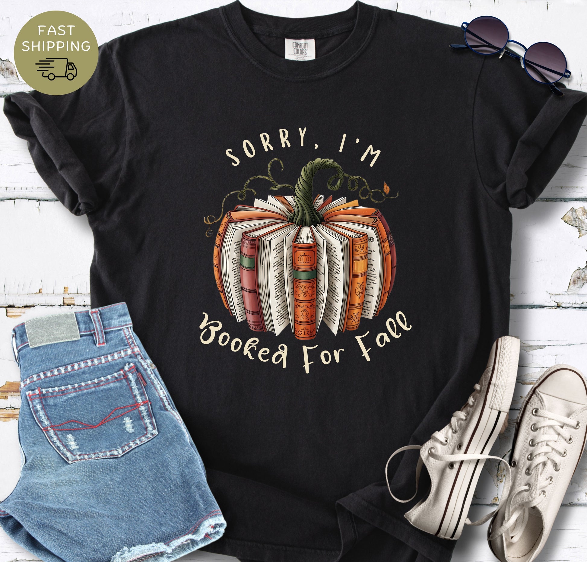 Book lover fall tee with warm autumn colours, book pages, vines, and pumpkin details.