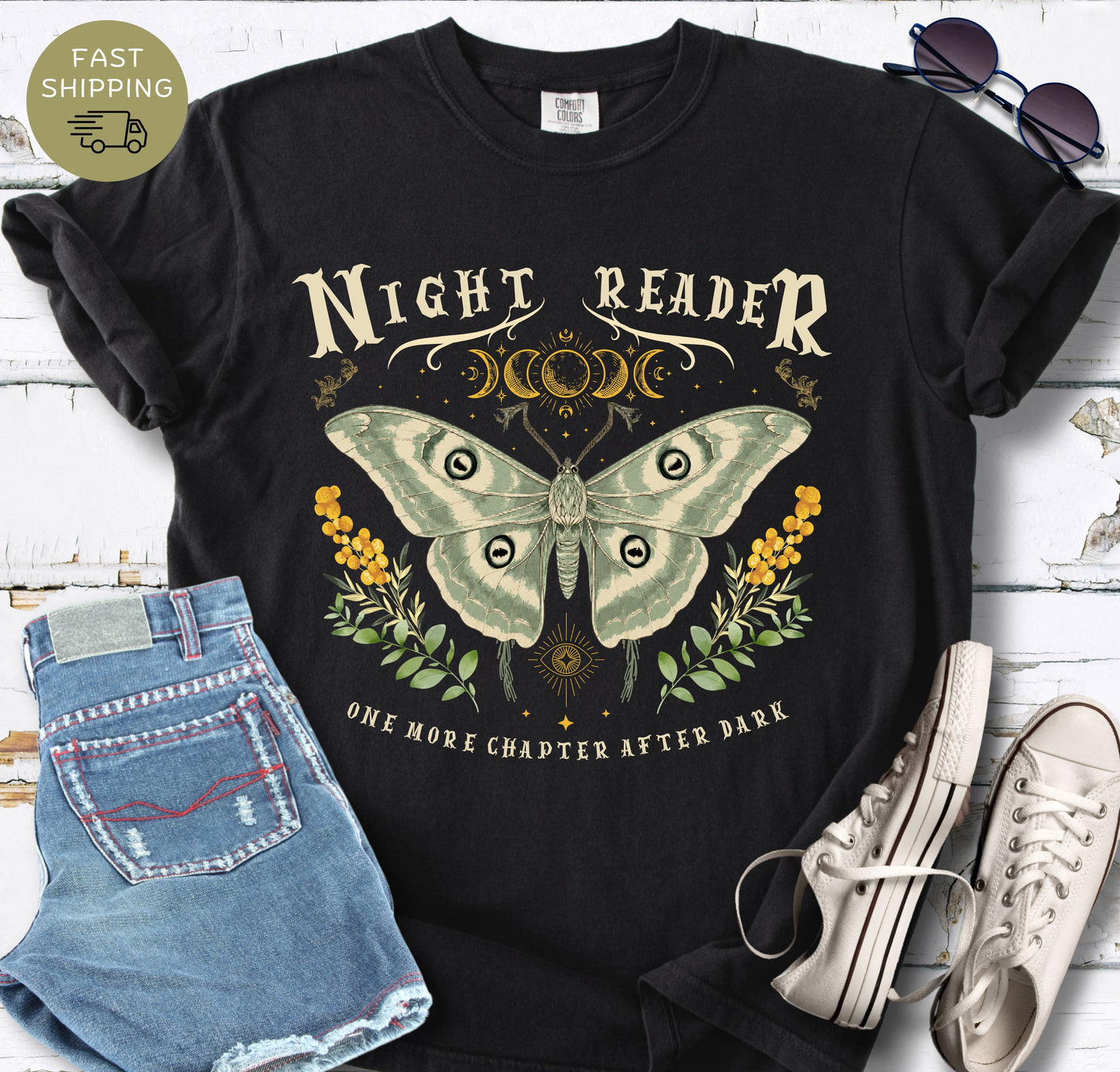 Black Comfort Colors T-shirt featuring the phrase “Night Reader” with a luna moth and moon phase design.