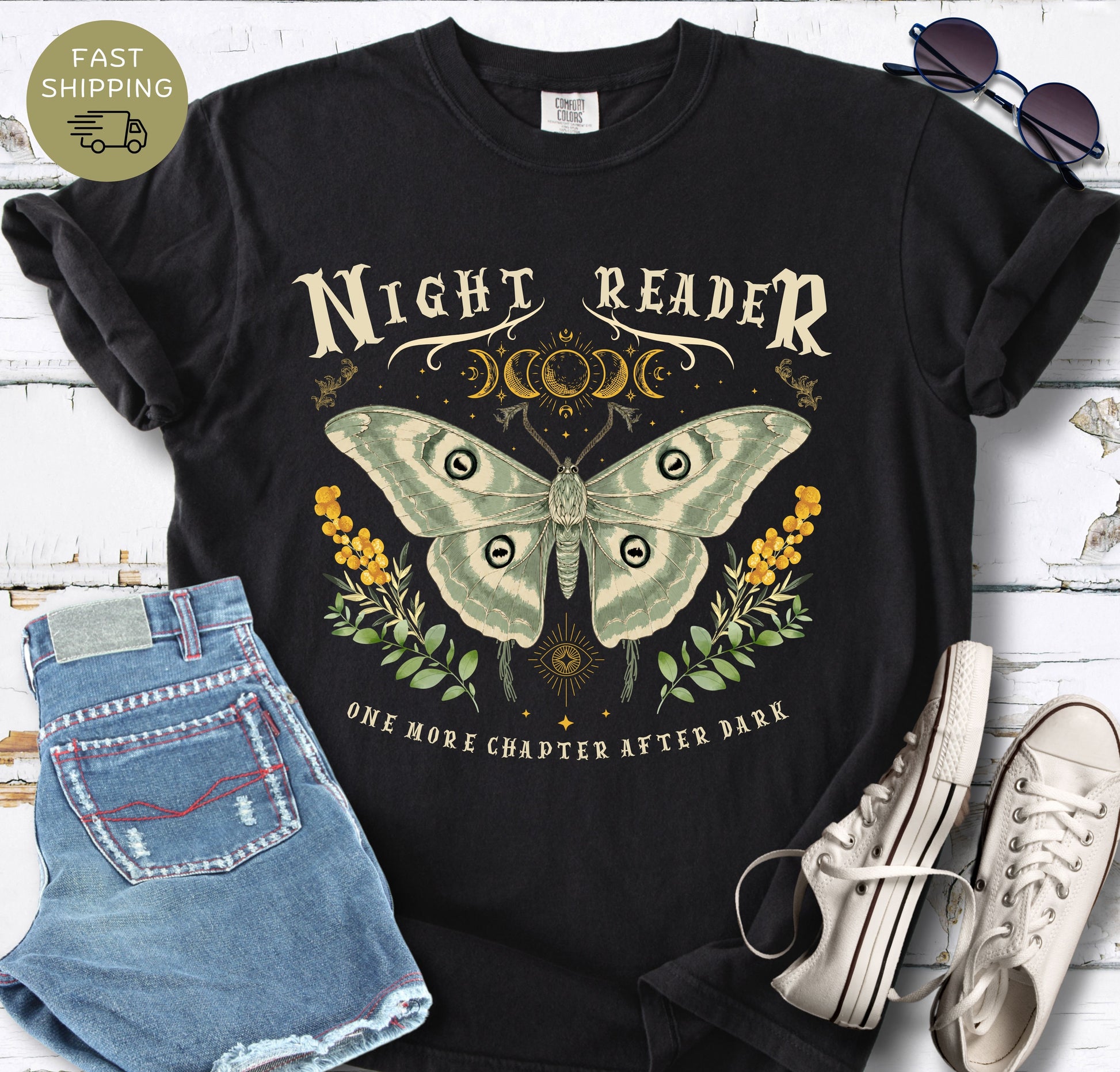 Black Comfort Colors T-shirt featuring the phrase “Night Reader” with a luna moth and moon phase design.