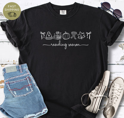 Black reader shirt with pumpkin, books, coffee cup, scarf, and leaf design.