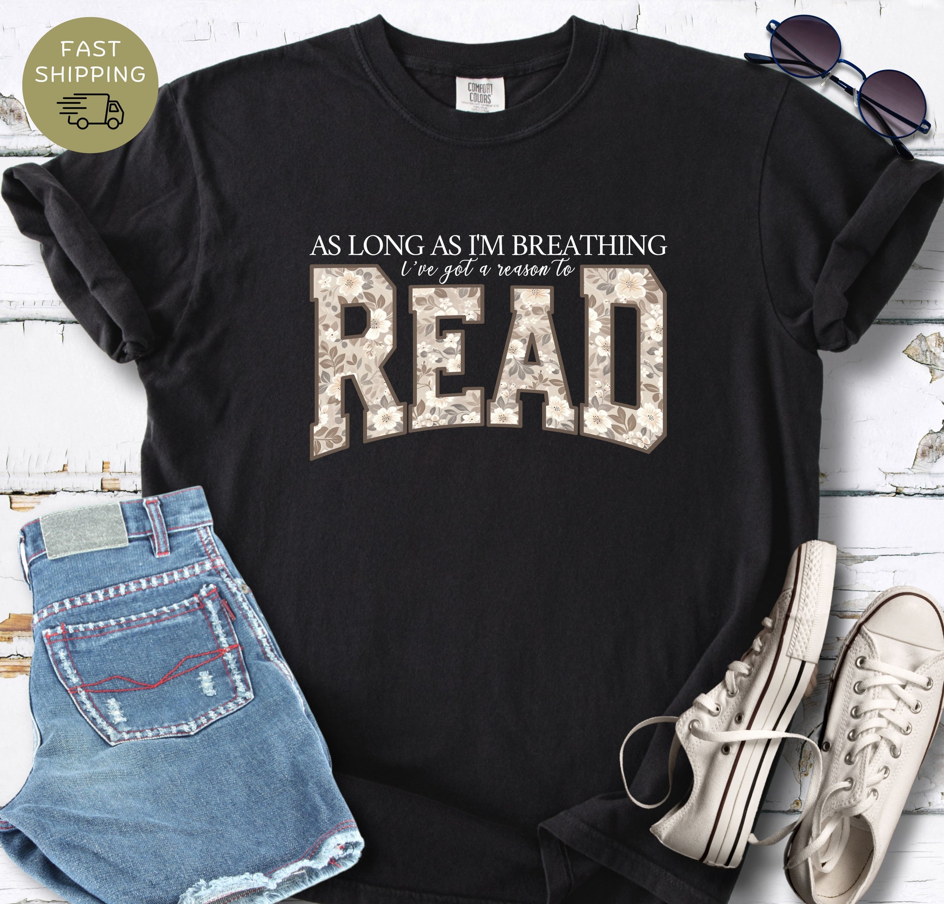Women’s bookish tee with black floral letters and a soft vintage-inspired colour palette.
