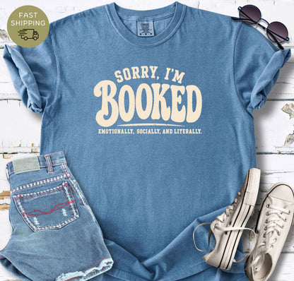 Bookish graphic tee styled flat lay with jeans, sneakers, and sunglasses.