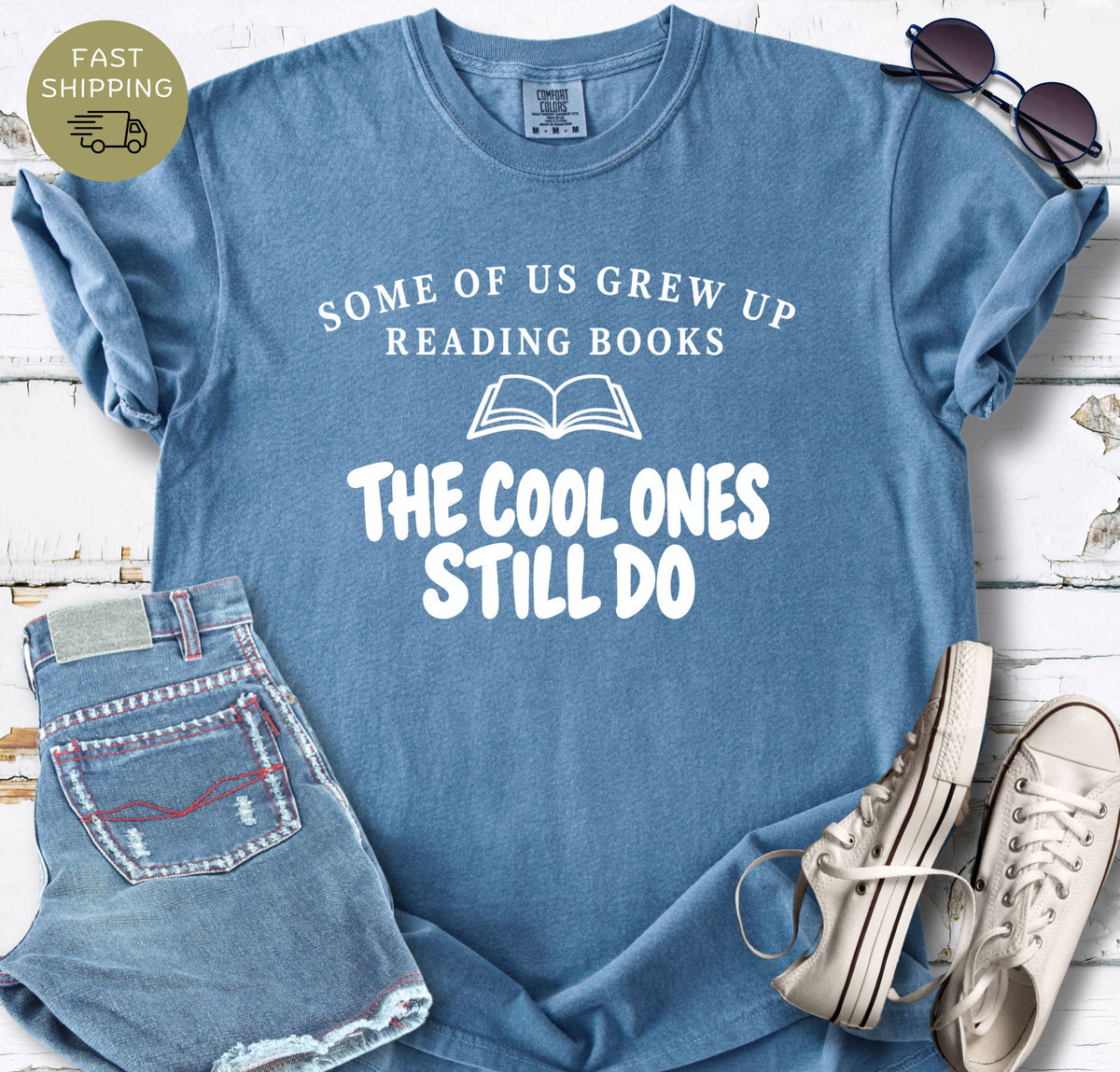 Blue Jean Comfort Colors t-shirt with white text reading Some of Us Grew Up Reading Books The Cool Ones Still Do.