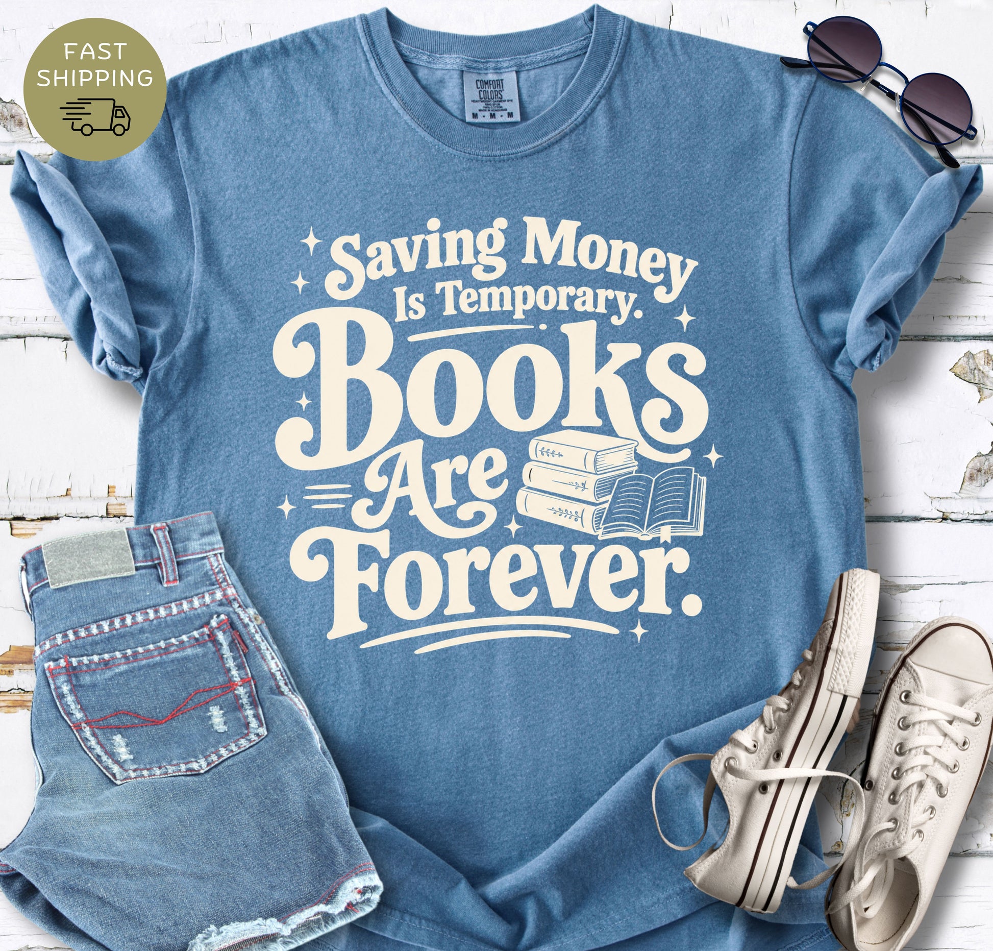 Women’s bookish T-shirt in blue jeans styled with denim shorts, sunglasses and white trainers.