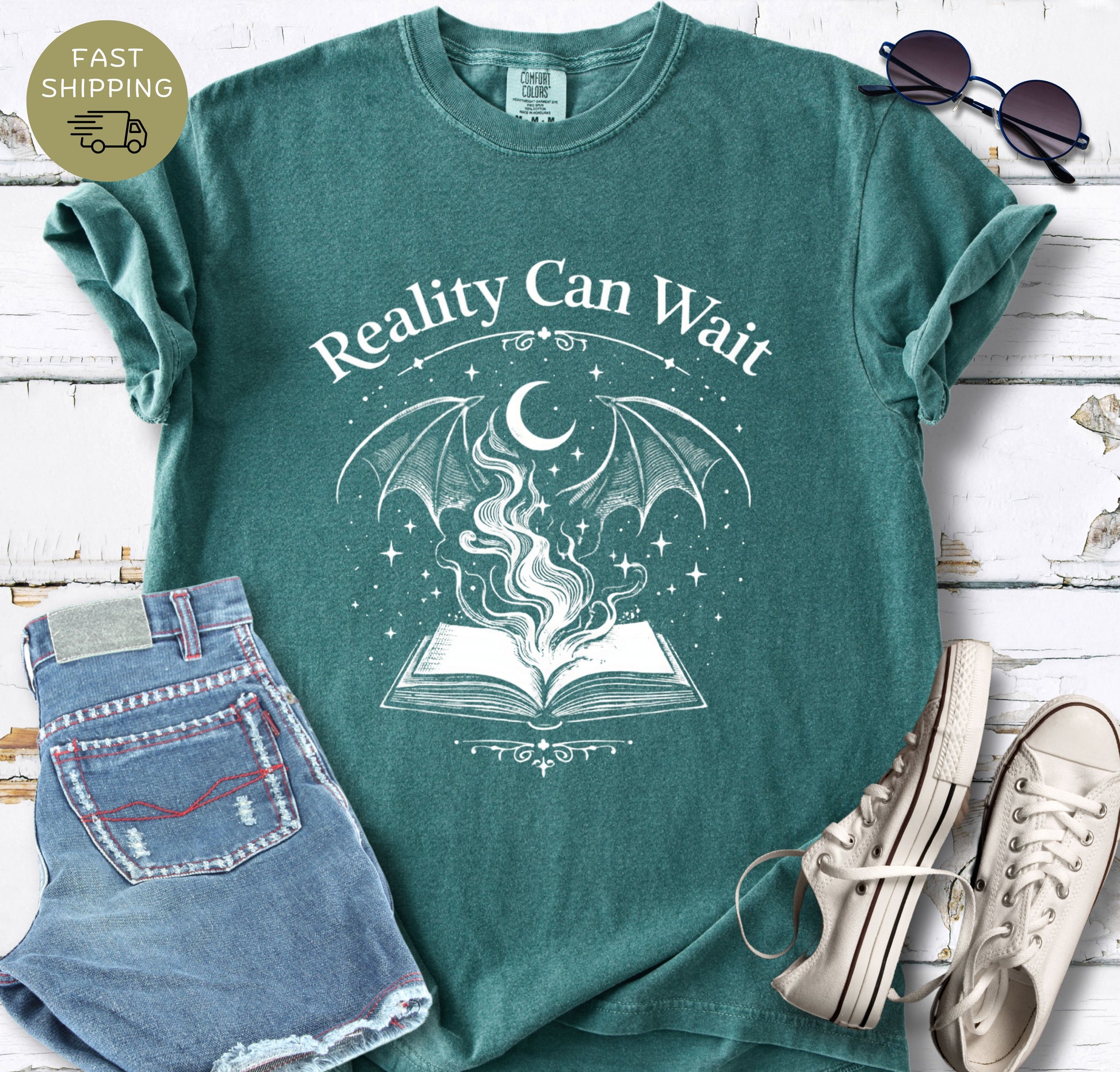 Reality Can Wait fantasy bookish t-shirt with open book and magical design on Comfort Colors 1717 blue spruce