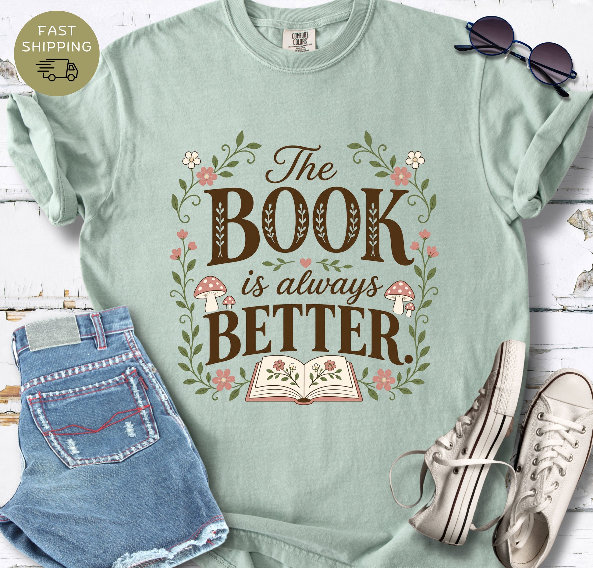Cottage core bookish shirt with flowers, mushrooms, and open book illustration