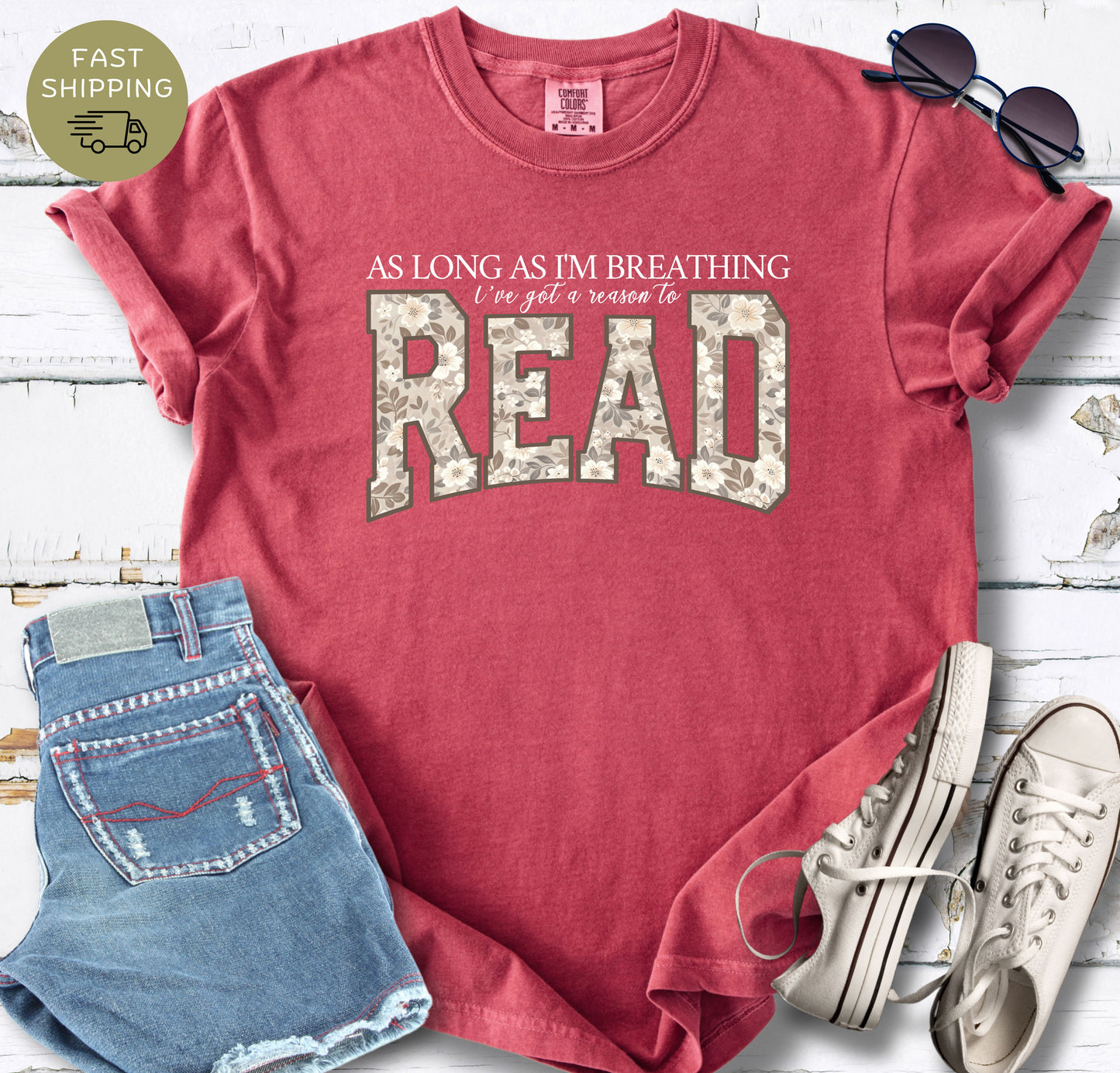 Casual Comfort Colors book lover T-shirt with a large floral “READ” design.