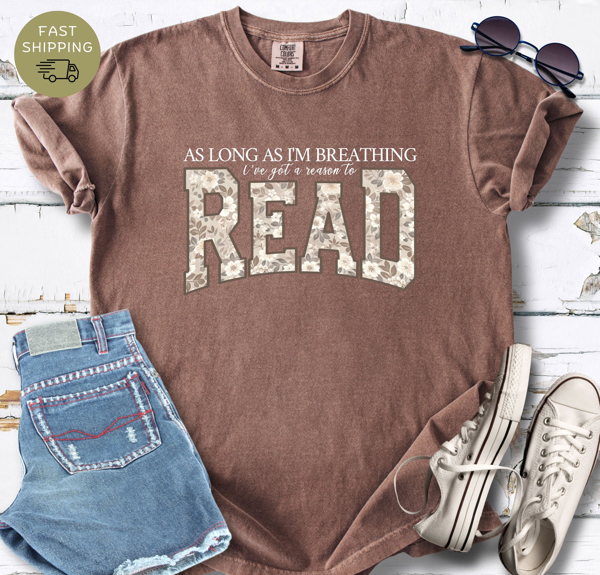 Close-up of a floral bookish design printed on a espresso garment-dyed Comfort Colors shirt.