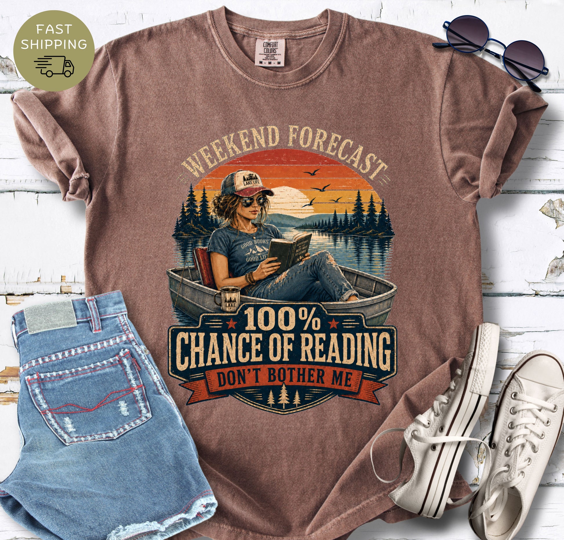 Vintage-inspired reader shirt with a boat, lake scene and bold “100% Chance of Reading” lettering.