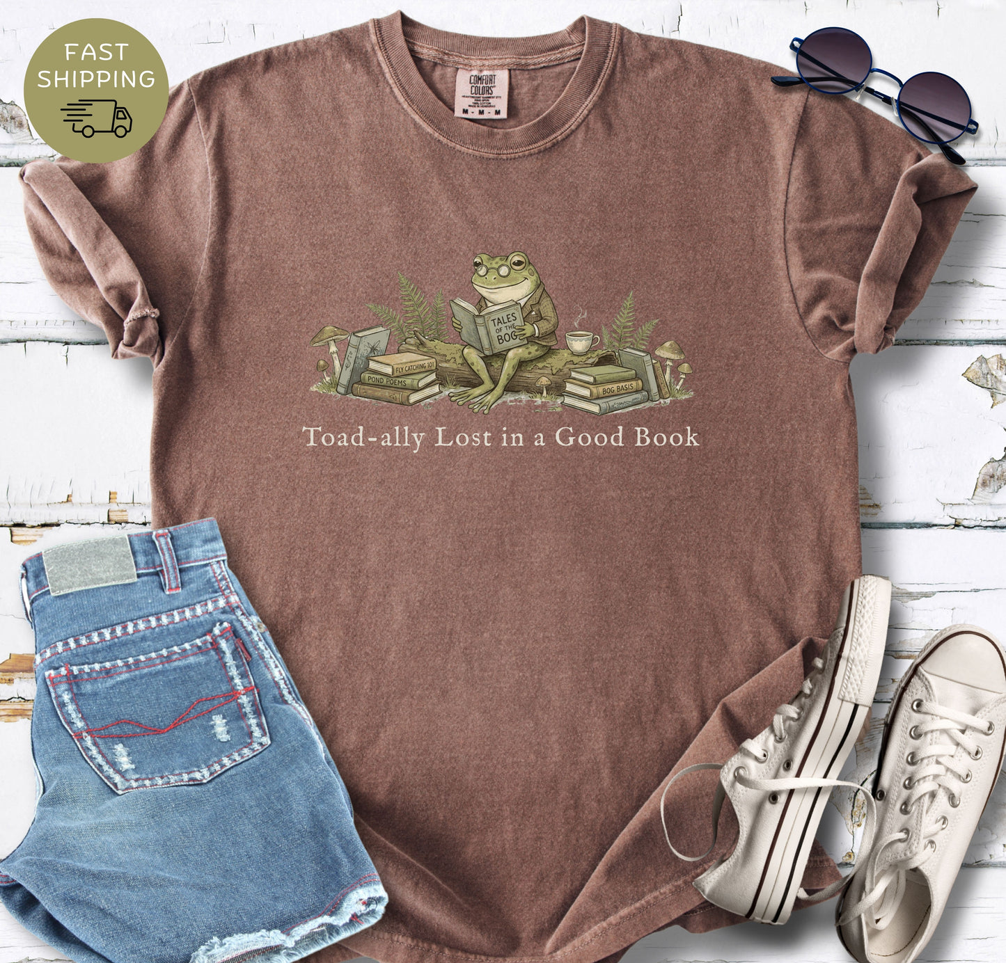 Cozy bookworm shirt with frog and stack of books illustration