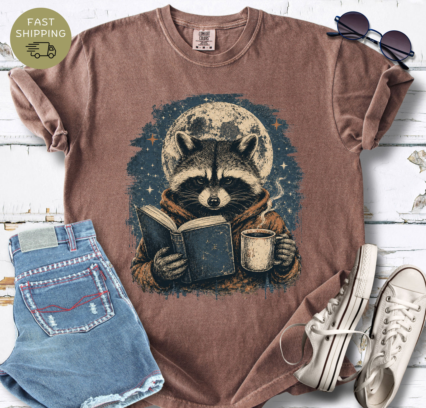 Espresso Comfort Colors t-shirt featuring a raccoon reading a book under a full moon.