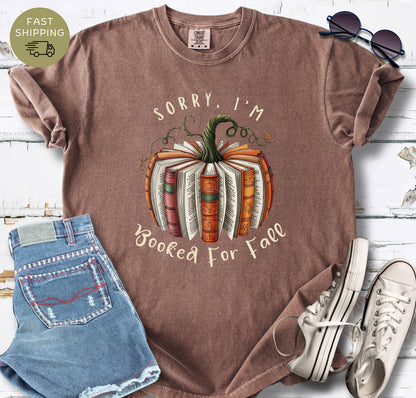 Cosy autumn reader tee with book pumpkin artwork and cream handwritten text.