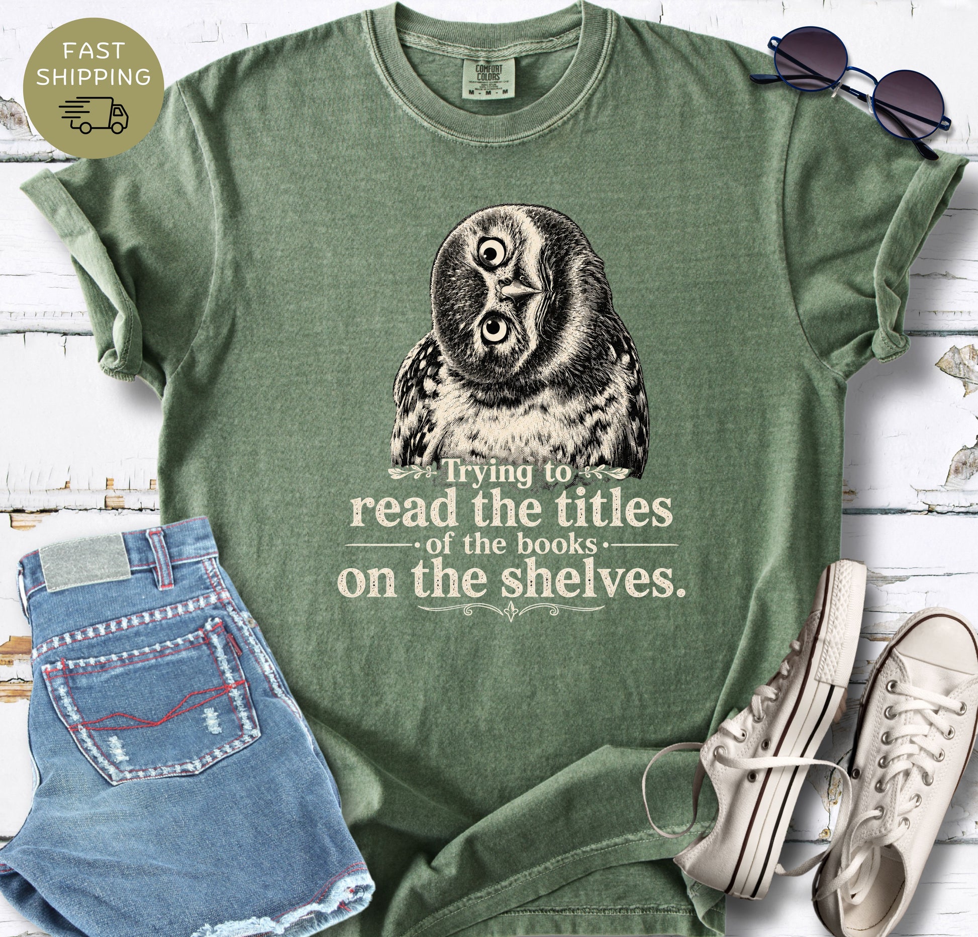 Women’s bookish T-shirt in dark grey styled with denim shorts, sunglasses and white trainers.