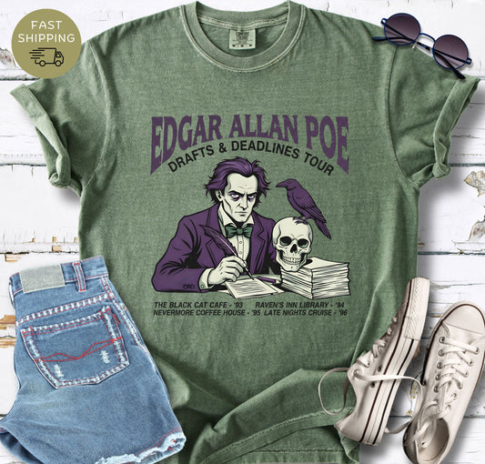 Illustrated Edgar Allan Poe wearing a purple suit, writing at a desk with a raven and skull, styled like a vintage literary tour t-shirt design.