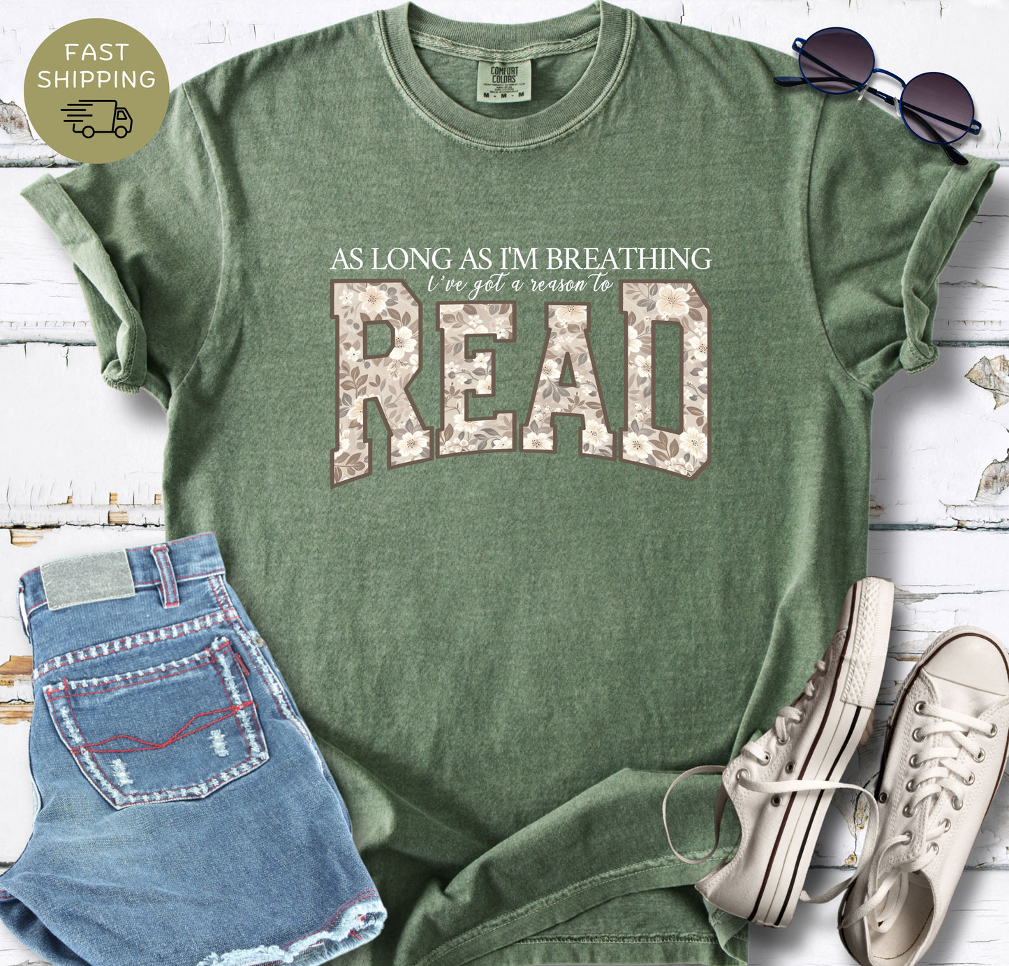 Women’s book lover graphic tee styled with denim shorts, sunglasses and white trainers.