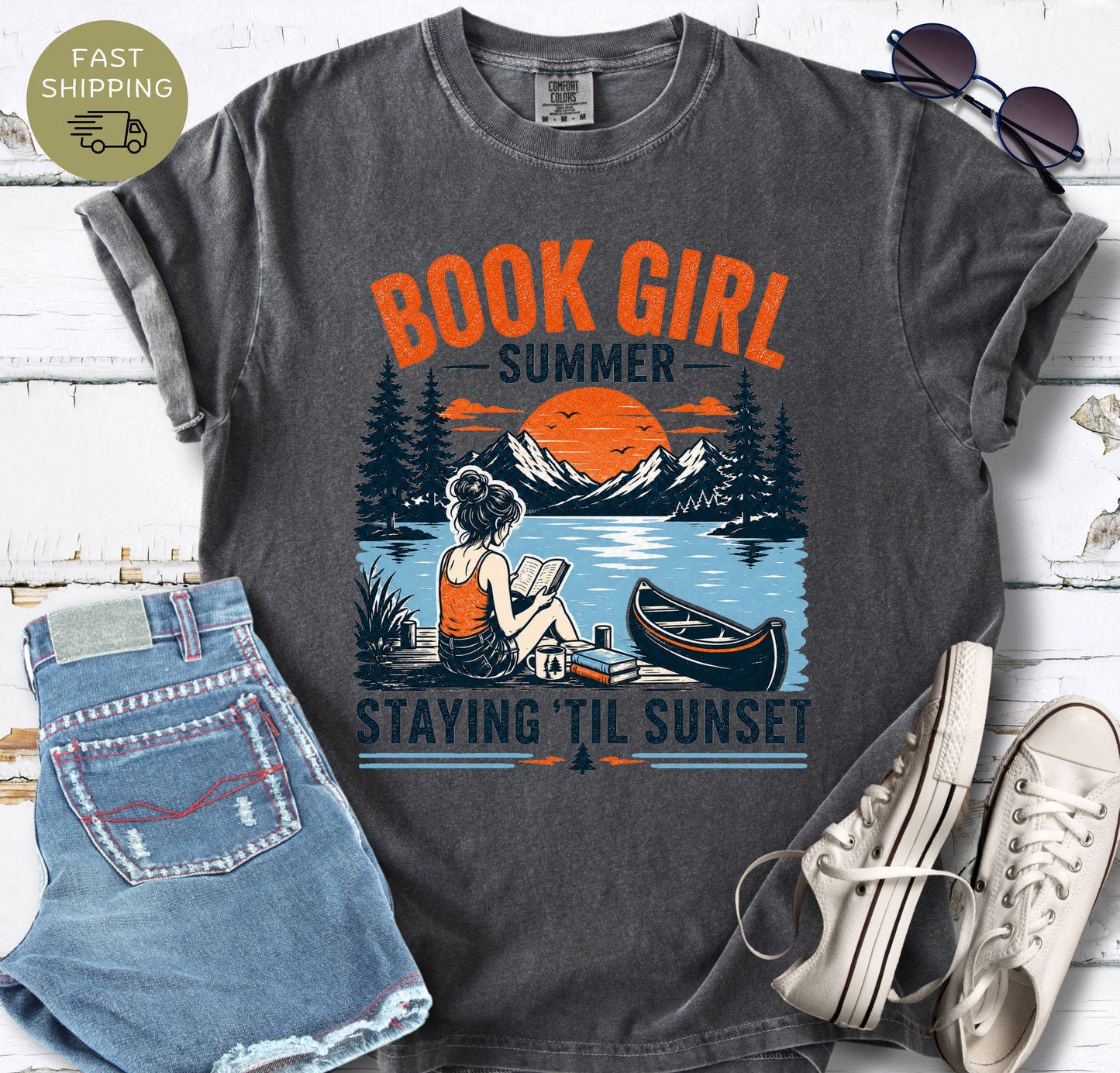 book lover tee featuring sunset, canoe, and reading girl illustration