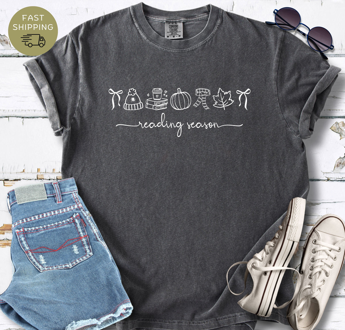 Autumn book lover t-shirt with simple line art and handwritten reading season phrase.