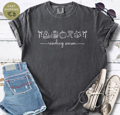 Autumn book lover t-shirt with simple line art and handwritten reading season phrase.