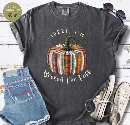 Bookish fall graphic tee with orange books, pumpkin stem, and curling green vines.