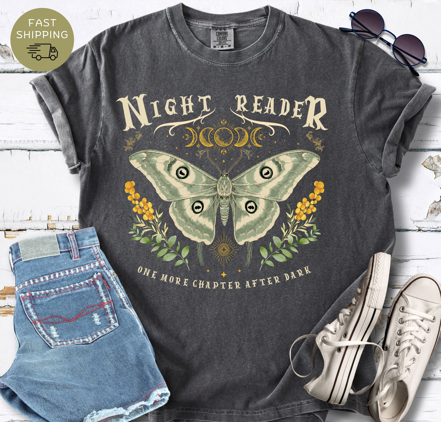 Pepper garment-dyed tee with “Night Reader” text and soft green, gold and black artwork.