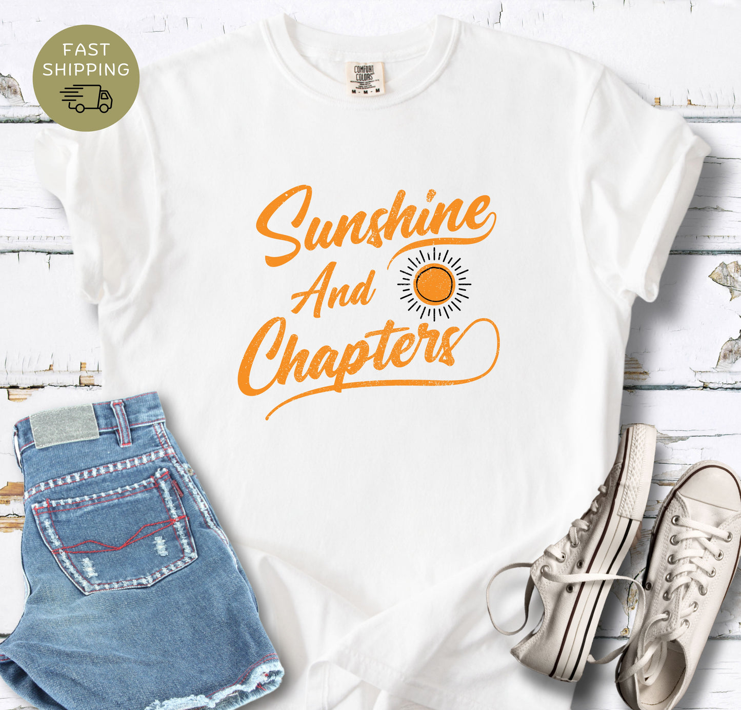 Retro reader apparel featuring a sun graphic and cursive text on a white  comfort colors shirt.