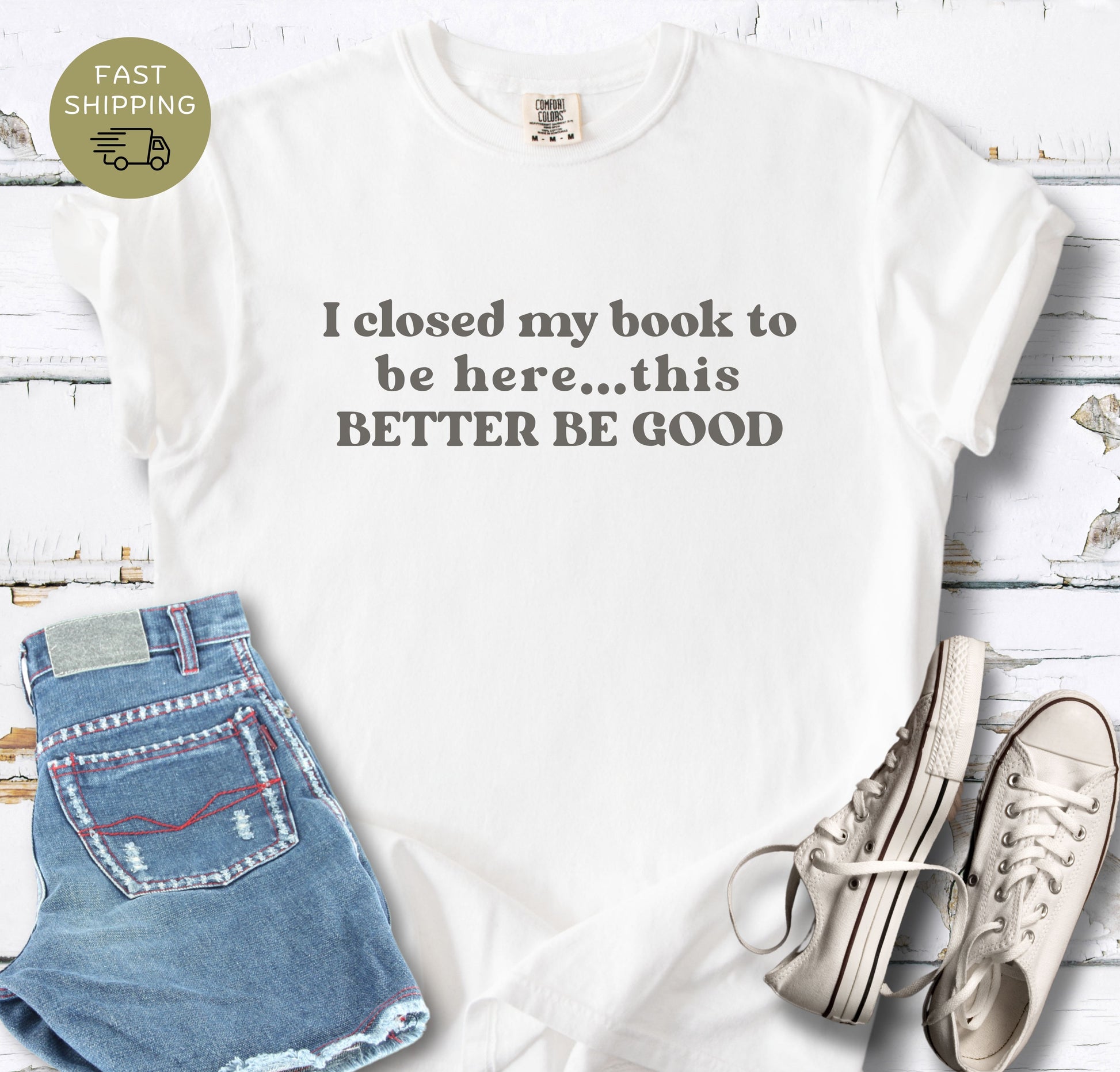 A soft, garment-dyed [Color] t-shirt with a vintage-style "book lover" quote. The image highlights the fabric texture and the contrast between the White material and the light gray lettering.